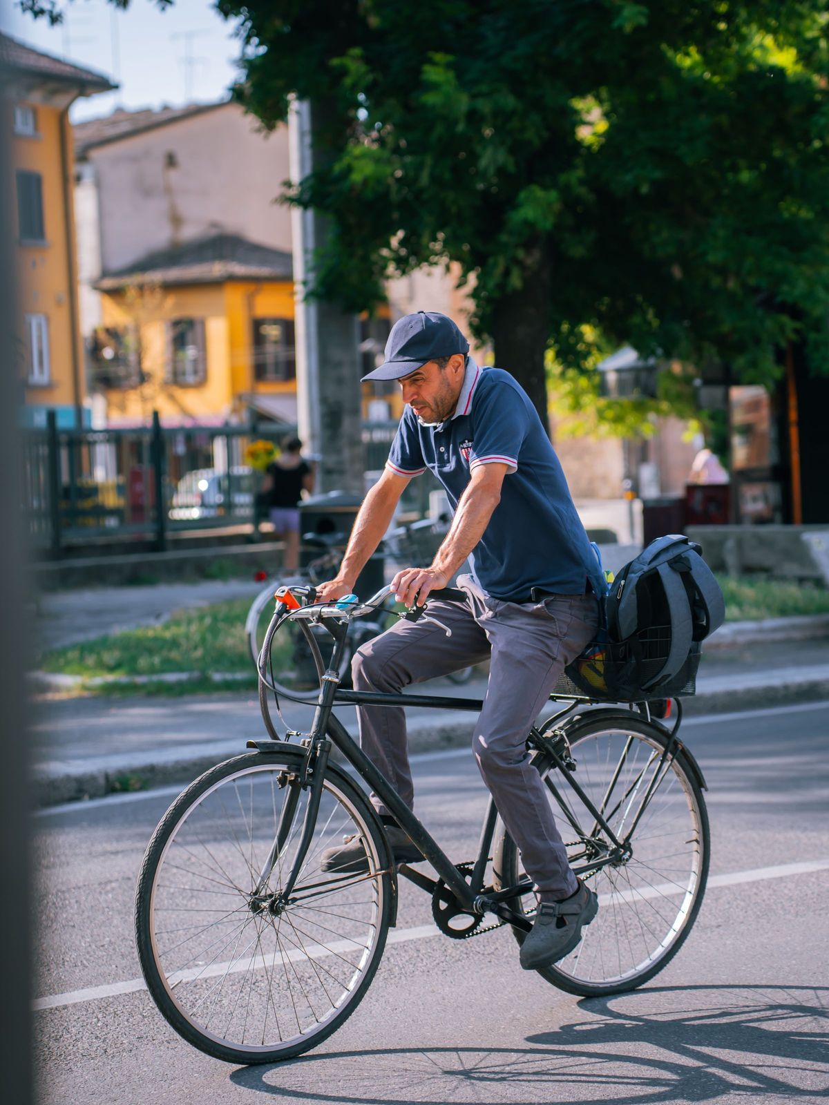 A man cycling to work along a sunny city street