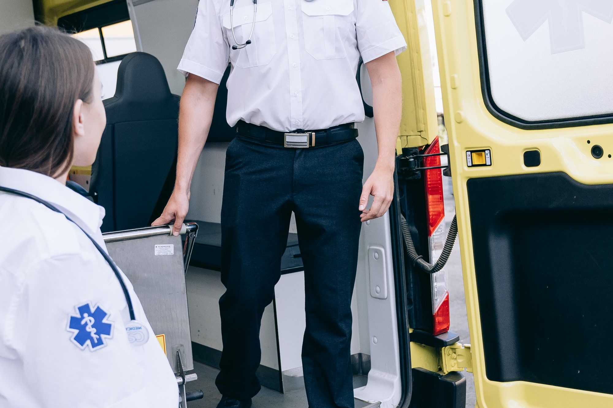 Paramedics preparing equipment in the back of an ambulance