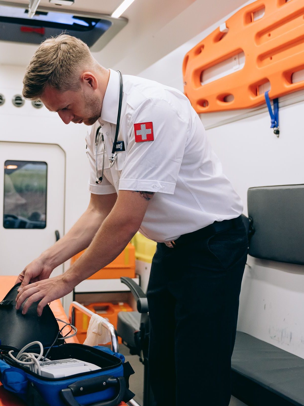 A medic checking a kit bag inside an ambulance