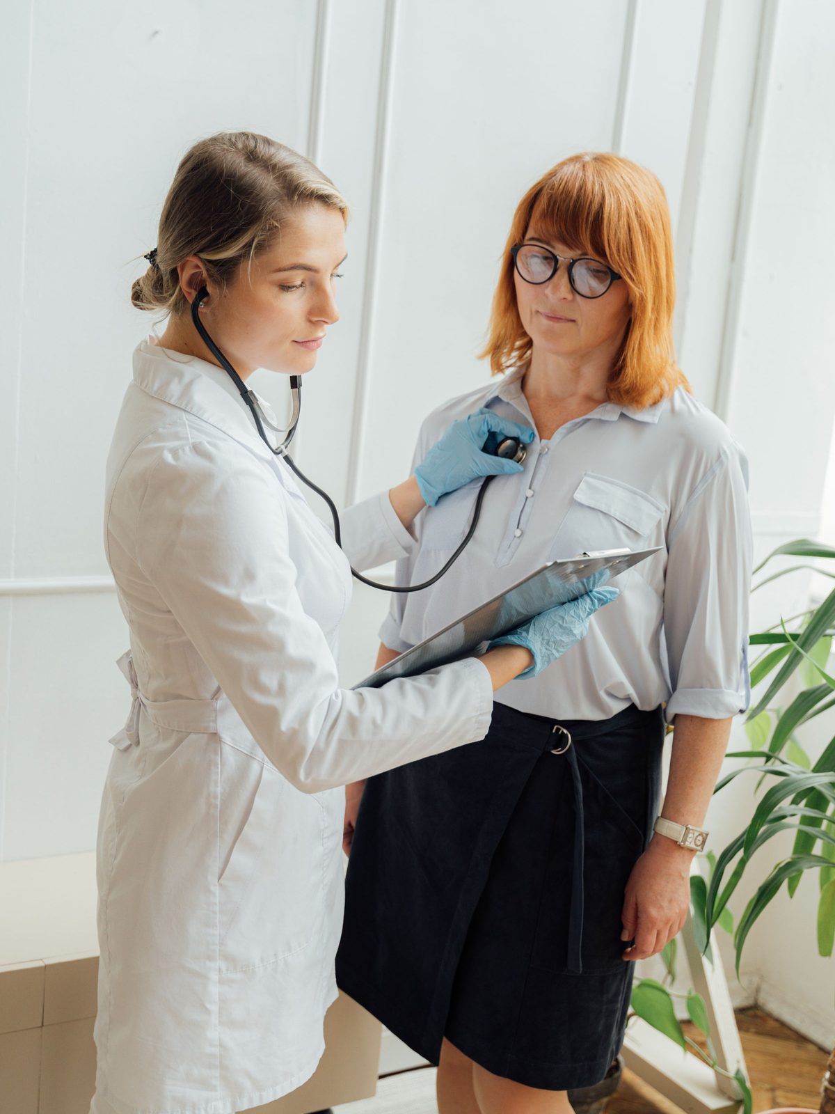 A doctor listening to a patient’s chest with a stethoscope